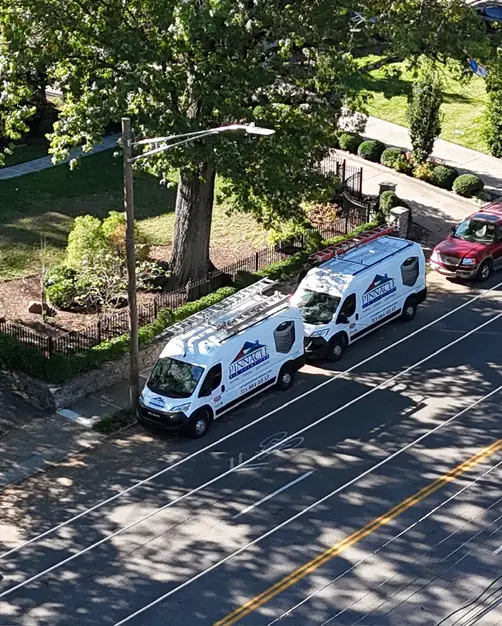 Two Pinnacle Air Solutions branded fleet vans parked on a Cincinnati residential street