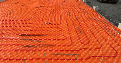 Radiant floor heating tubing laid across an entire basement slab before the concrete pour