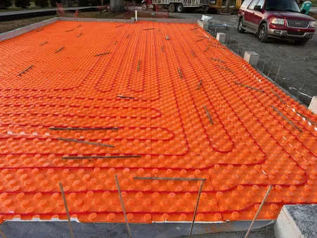 Radiant floor tubing installed across a full foundation slab before concrete pour