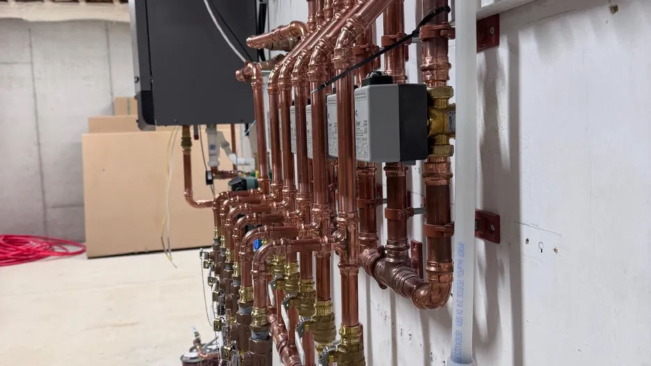 Finished radiant heating mechanical room with manifold and boiler equipment
