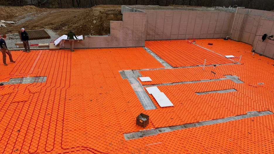PEX radiant floor tubing laid out across a foundation slab before the concrete pour